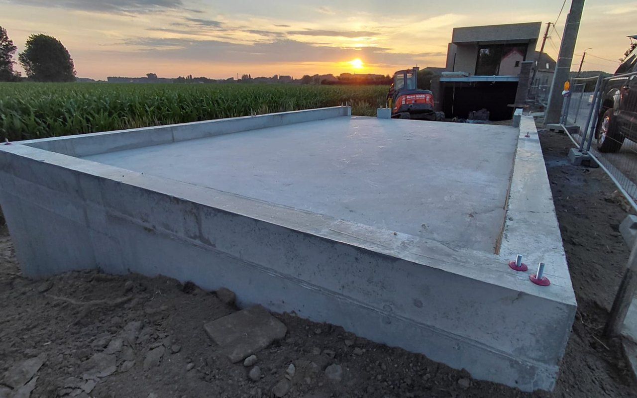Betonnen fundering op de bouwplaats bij zonsondergang